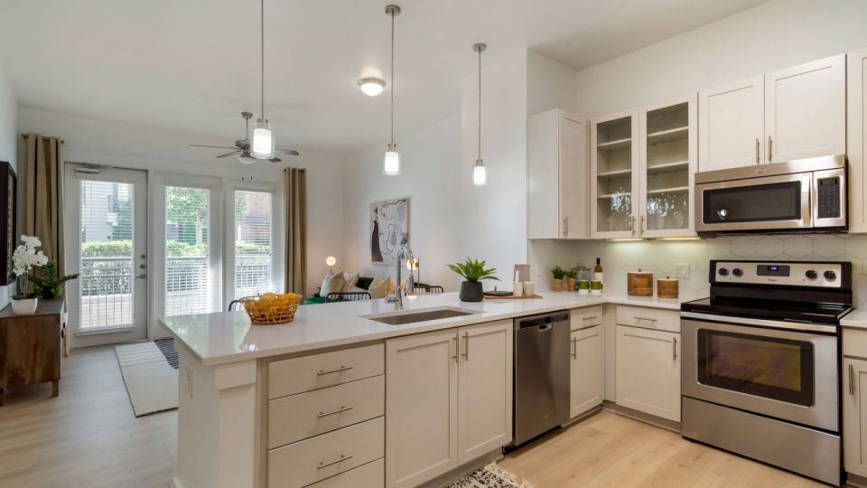 a kitchen with stainless steel appliances and white cabinets at The Allure