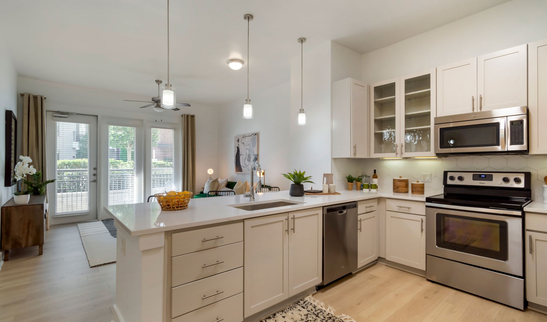 a clean kitchen with stainless steel appliances and white cabinets at The Allure