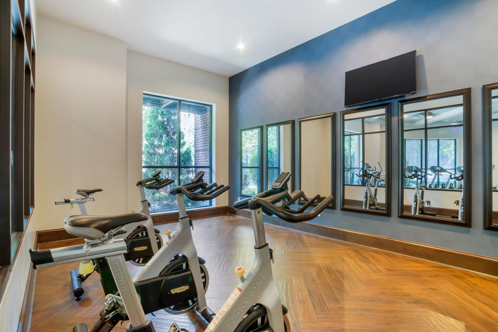 a gym room with exercise bikes and mirrors at The Allure