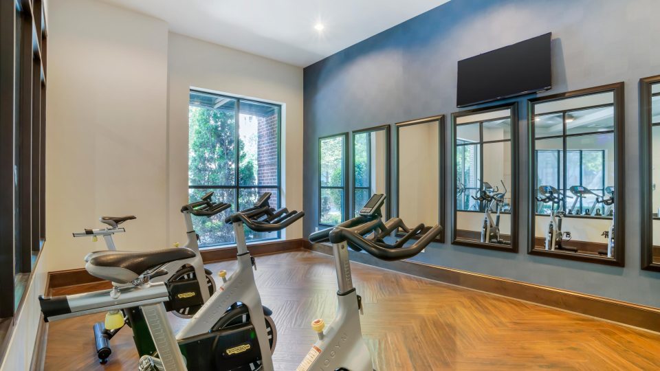 a gym room with exercise bikes and mirrors at The Allure